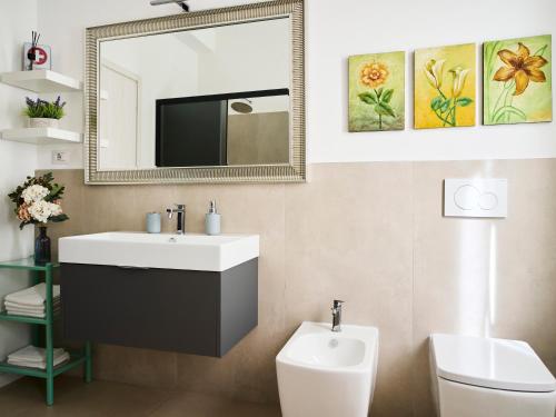 a bathroom with a sink and a mirror and a toilet at il 64B - 10 minuti a piedi dal Policlinico San Matteo - in Pavia
