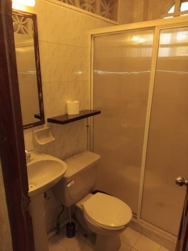 a bathroom with a toilet and a sink and a shower at Bungalow Encanto in Zihuatanejo