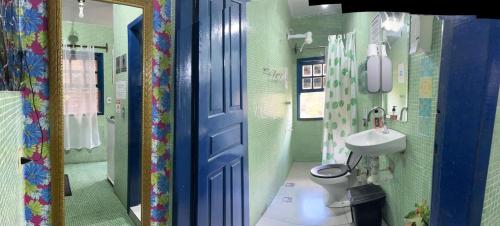 a bathroom with a blue door and a toilet and a sink at Uai hostel in Ouro Preto