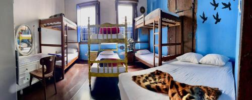 a room with three bunk beds and a blue wall at Uai hostel in Ouro Preto