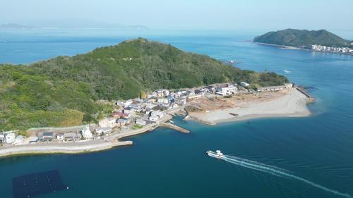 ein Boot im Wasser neben einer kleinen Insel in der Unterkunft NOMAyado in Naruto