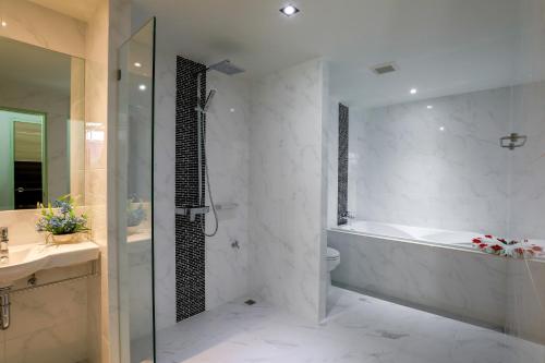 a bathroom with a tub and a toilet and a sink at Grandpink park hotel in Hat Yai