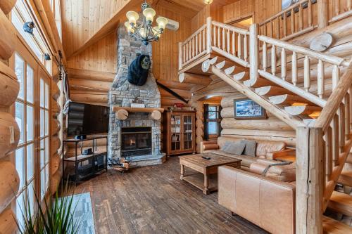 a living room with a staircase and a fireplace at Fiddler Lake Resort - Bear 14 in Mille-Isles