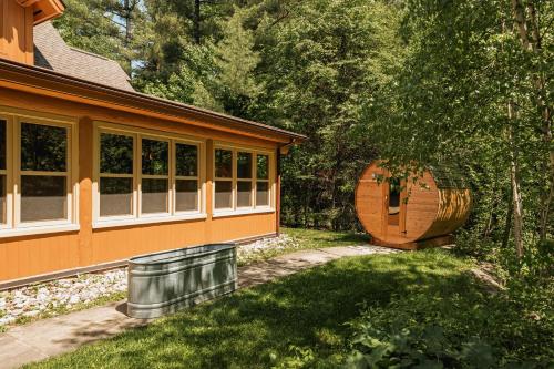a house with a barrel in front of it at Fiddler Lake Resort - Bear 14 in Mille-Isles