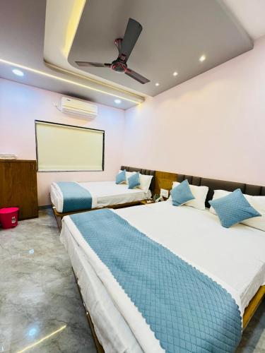 a room with two beds and a projection screen at Sairam Residency in Ellora
