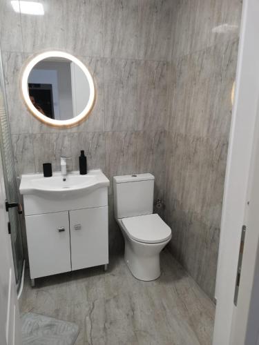 a bathroom with a white toilet and a mirror at Casa Lucy in Alexandria