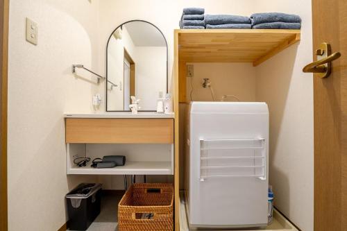 a small bathroom with a sink and a white refrigerator at B桜坂Sakurazaka APT in Susakiuramachi