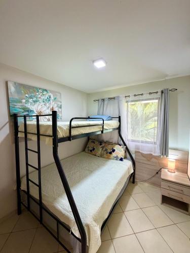 a bedroom with two bunk beds and a window at Charming condo with a rooftop, across beach in Coco
