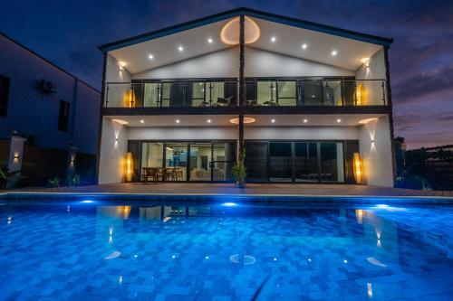 a house with a swimming pool in front of a building at Tides Apartments in Nadi
