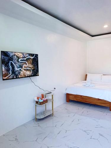 a bedroom with a bed and a painting on the wall at CHIEF'S VILLA Rentals Malapascua Island in Malapascua Island