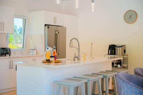 a kitchen with a counter with stools and a sink at Villa 107 in Sosúa
