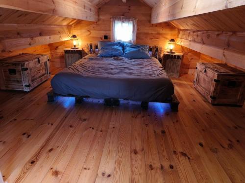 a bedroom with a bed in a log cabin at Charmant petit chalet jurassien in Saint-Lamain