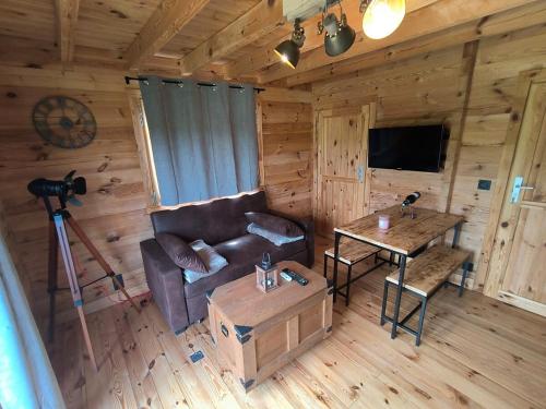 a living room with a couch and a table at Charmant petit chalet jurassien in Saint-Lamain