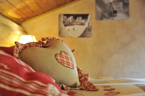 a heart pillow sitting on top of a bed at L'Ancien Paquier Chambre D'Hotes in Valtournenche