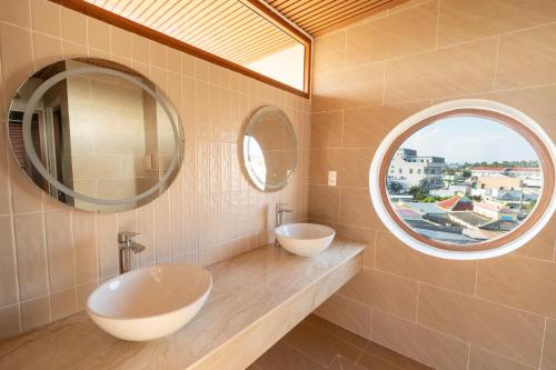 a bathroom with two sinks and a round window at Gió Villa in Ấp Sơn Hải