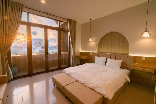 a bedroom with a large bed and a large window at Gió Villa in Ấp Sơn Hải