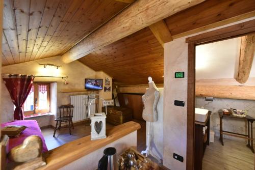 a living room with a wooden ceiling and a bedroom at L'Ancien Paquier Chambre D'Hotes in Valtournenche