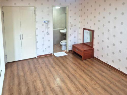 a bathroom with a toilet and a wooden floor at Muju Ilsung Condo in Muju