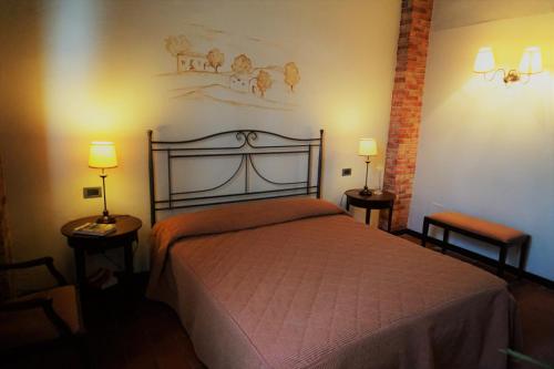 a bedroom with a bed with two lamps and two tables at Agriturismo Antico Borgo Poggitazzi in Loro Ciuffenna