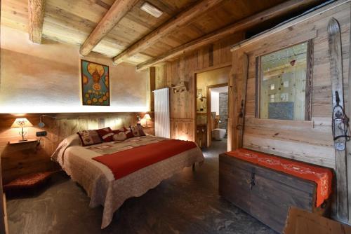 una camera da letto con un letto in una cabina di legno di L'Ancien Paquier Chambre D'Hotes a Valtournenche