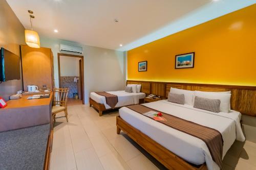 a hotel room with two beds and a desk at Bohol Beach Club in Panglao Island