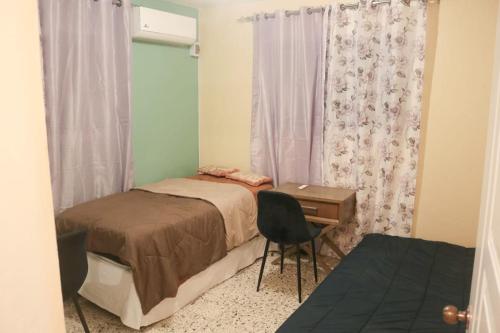 a bedroom with a bed and a desk and a window at Terraza Marina in Bajos de Haina