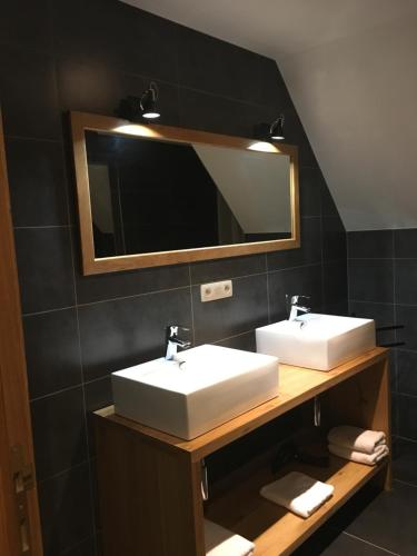 a bathroom with two sinks and a mirror at De Gouden Klokke in Avelgem