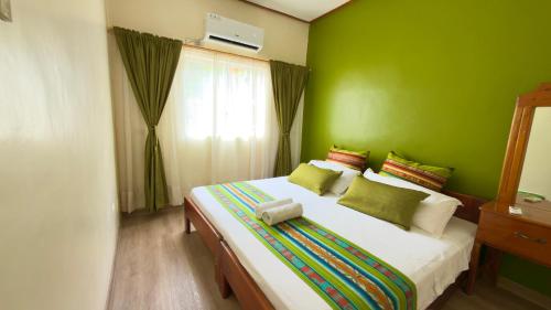 a bedroom with a large bed with green walls at Casa independiente in Puerto Ayora