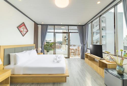 a bedroom with a white bed and a television at Peaceful 2 Hotel in Vientiane