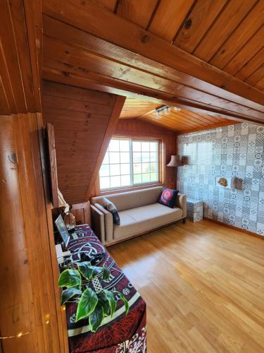 a living room with a couch in a room with wooden ceilings at 버킷 제주 - Bucket Jeju in Seogwipo
