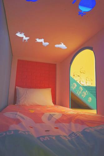 a bedroom with a bed and a window with clouds at Happy House Homestay in Hualien City