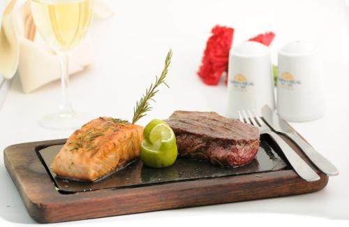 a steak and a piece of meat on a cutting board at Suites Camino Real in La Paz