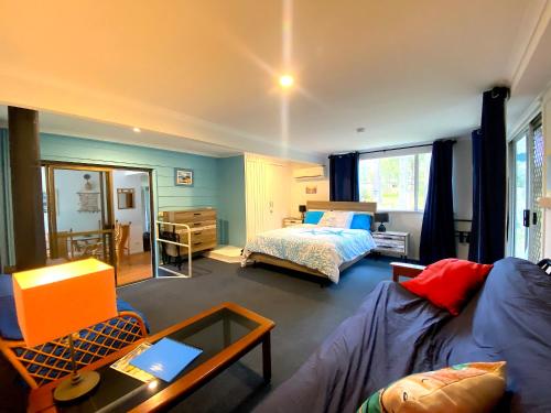 a living room with a bed and a couch at Lakeside 3-BR Forest Cottage in Laurieton