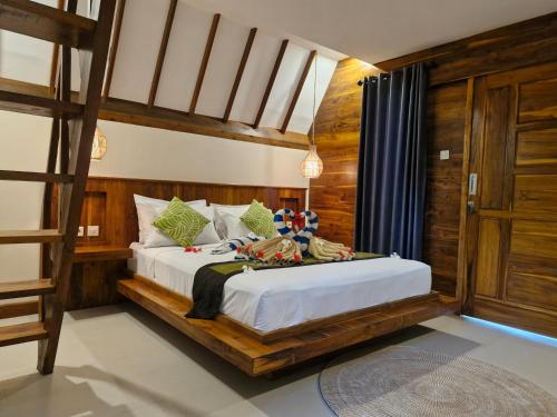 a bedroom with a bed and a bunk bed with a ladder at Lucy's Garden Hotel in Gili Islands