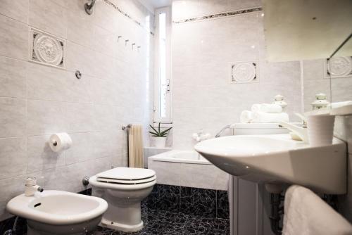 Baño blanco con aseo y lavamanos en Porta Latina Apartment en Roma