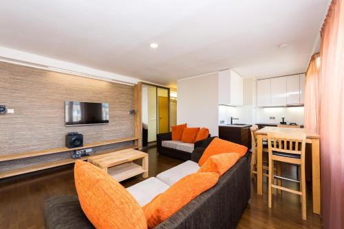 - un salon avec un canapé et des fauteuils orange dans l'établissement City Center Studio Apartment, à Tallinn