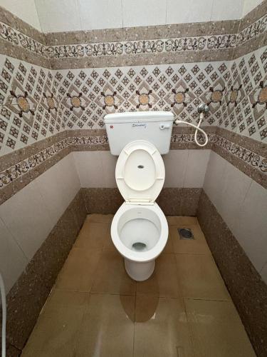 a bathroom with a white toilet in a room at Neon Villa in Pondicherry