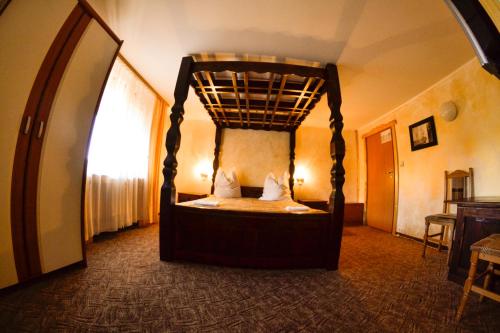 a bedroom with a canopy bed in a room at Pension Restaurant Speranta in Predeal