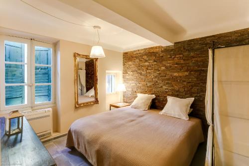 Un dormitorio con una cama y una pared de ladrillo. en Florella Félix Faure, en Cannes