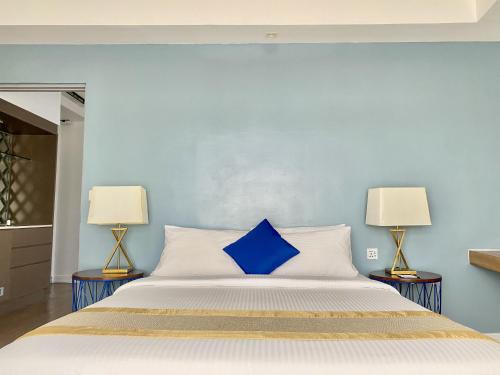 a blue bedroom with a bed with two lamps at Ferra Hotel and Garden Suites in Boracay