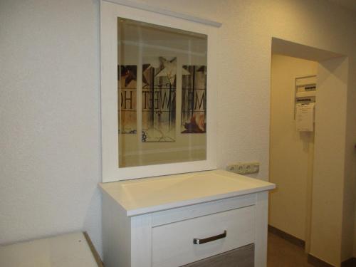 a bathroom with a white cabinet with a mirror at Ferienwohnung Kopp II in Greiz