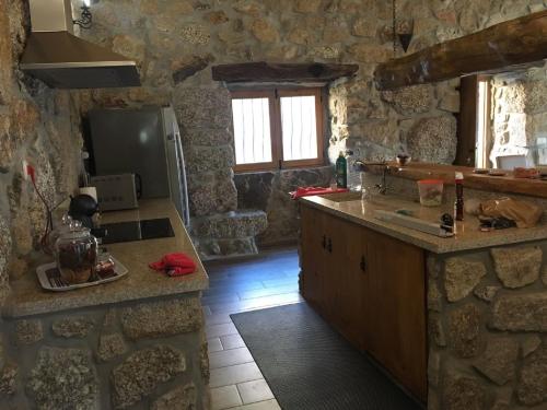 eine Küche mit Steinwänden und einer Arbeitsplatte in der Unterkunft Casa de Basto in Celorico de Basto