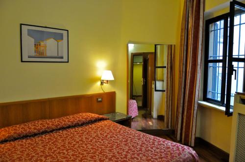 a hotel room with a bed and a mirror at Hotel Vecchia Milano in Milan
