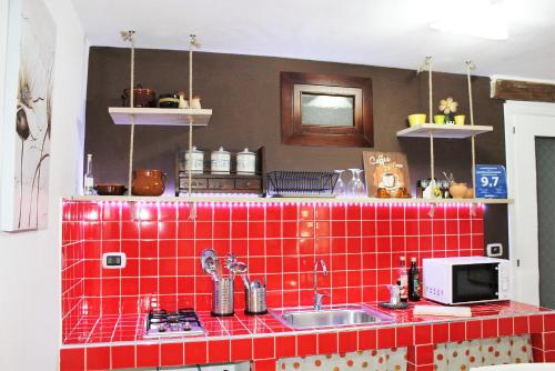 ピアッツァ・アルメリーナにあるGuest House La Casettaの赤いタイル張りのカウンター付きキッチン