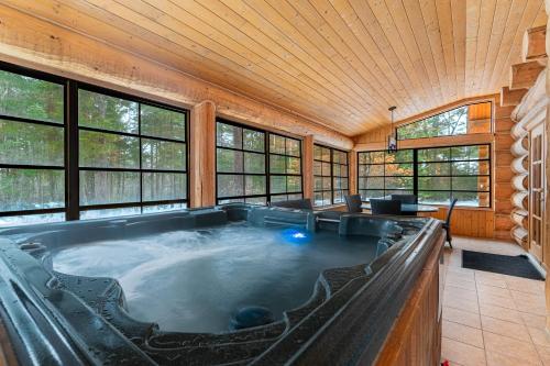 a hot tub in a room with windows at Fiddler Lake Resort - Bear 22 in Mille-Isles