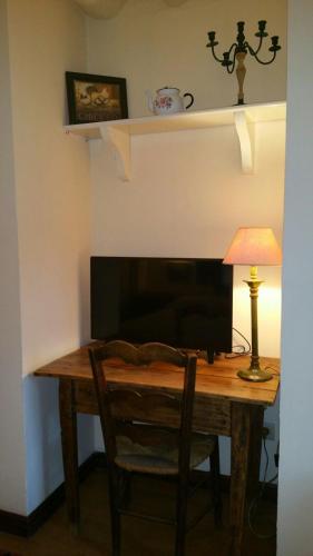 a desk with a television and a lamp on a table at Casa Rural Las Pedrolas in Arnedillo