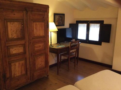 a room with a desk and a table with a window at Casa Rural Las Pedrolas in Arnedillo