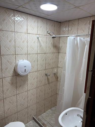 a bathroom with a shower and a toilet and a sink at Hospedaje Alejandra in Canoas
