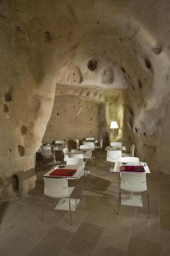 a room with tables and chairs in a cave at Antico Convicino Rooms Suites & SPA in Matera