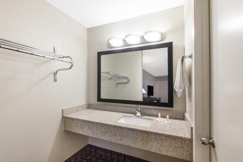 a bathroom with a sink and a mirror at Days Inn by Wyndham Ennis in Ennis